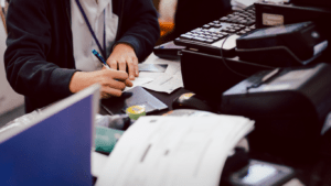 a person sitting at a desk writing on a piece of paper