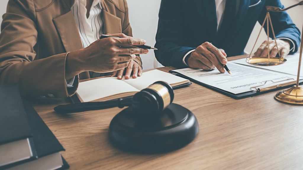 two people sitting at a desk with a gavel