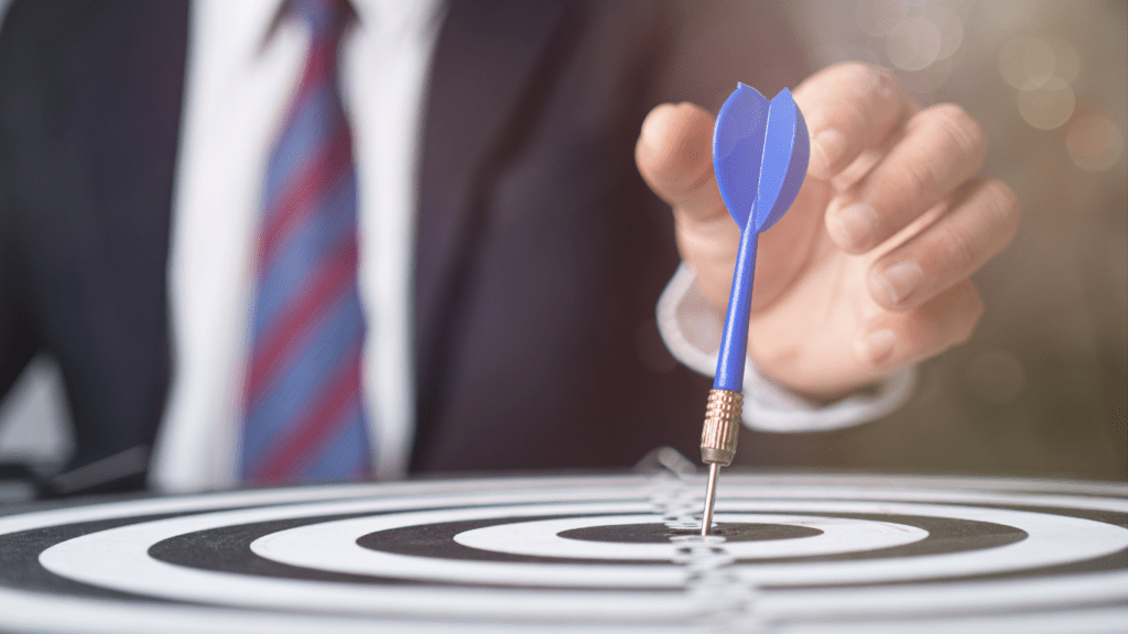 a person in a suit holding a dart in the center of a target