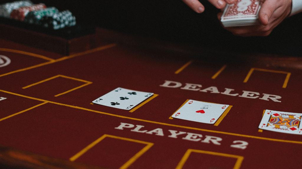 a person in a suit and tie playing cards at a casino table