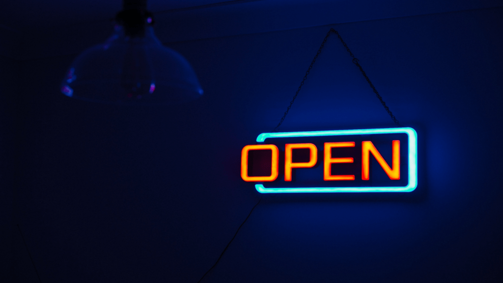 an open sign hanging from a string