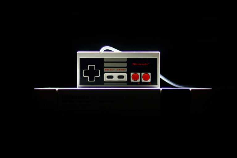 A close-up of a classic NES controller with dramatic lighting on a black background, evoking nostalgia.