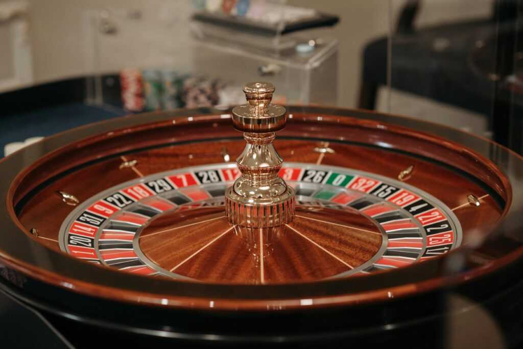 Close-up of a classic roulette wheel in a casino setting showcasing the elegant wooden design.